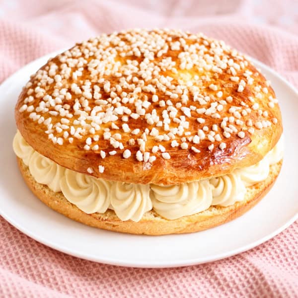 Tarte tropézienne maison garnie de crème à la fleur d’oranger et parsemée de sucre perlé