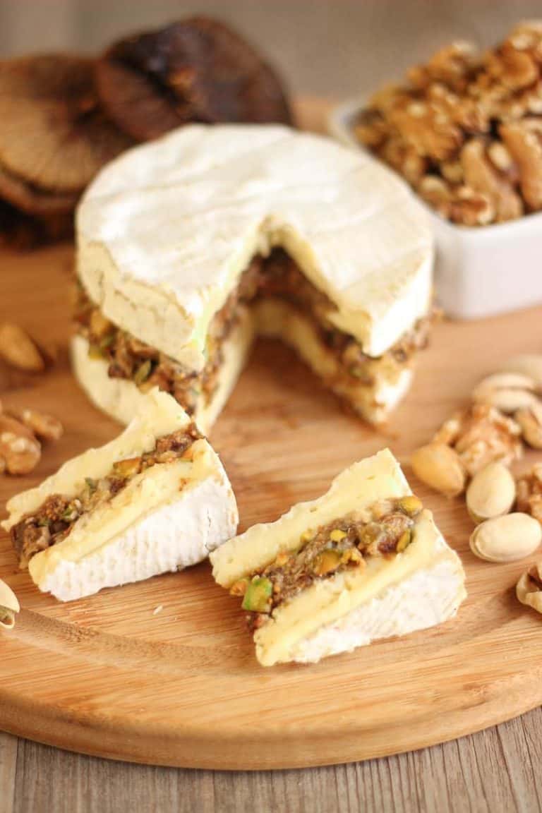 Camembert farci aux noix, pistaches et figues sur planche à découper
