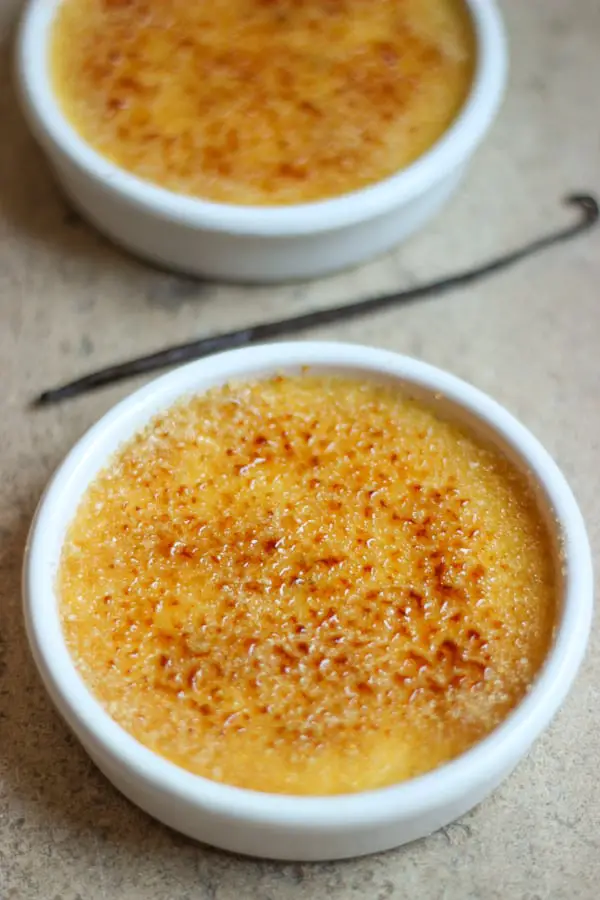 Crème brulée dans ramequin blanc avec gousse de vanille