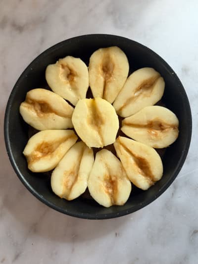 Demi-poires disposées en cercle sur le caramel, face coupée vers le haut.