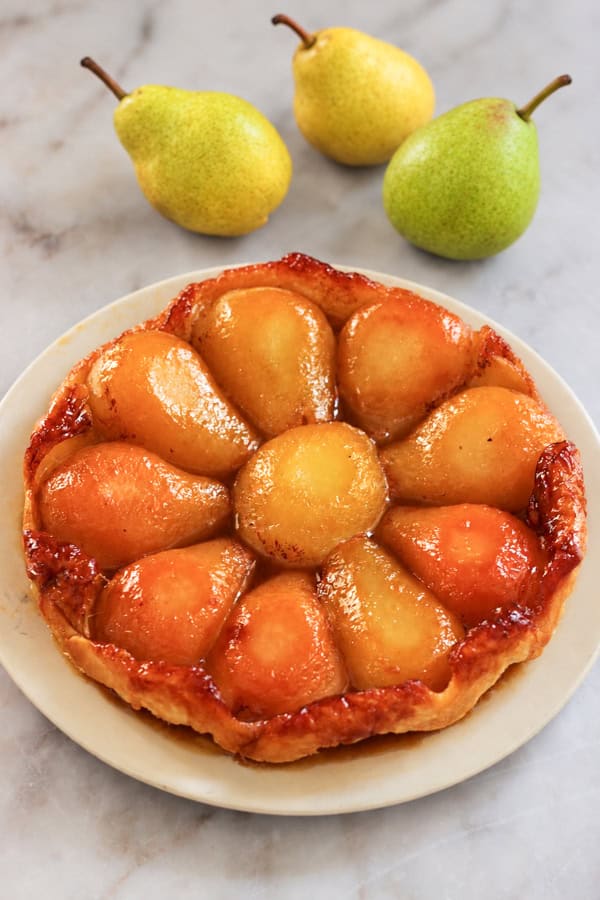 Tarte Tatin aux poires caramélisées au beurre salé sur une pâte feuilletée dorée.