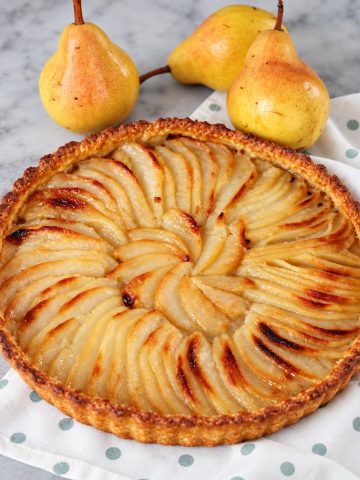 Tarte aux poires sur pâte sablée dorée, garnie de lamelles de poires fondantes et légèrement caramélisées.